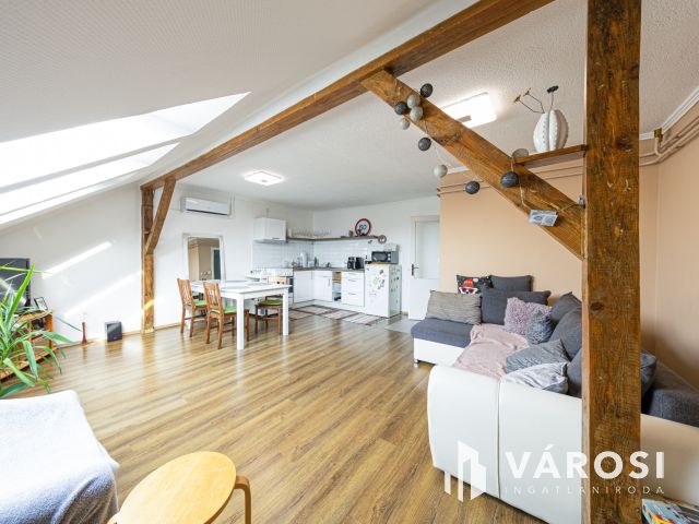 Látszó fagerendás tetőtéri lakás csendes utcában